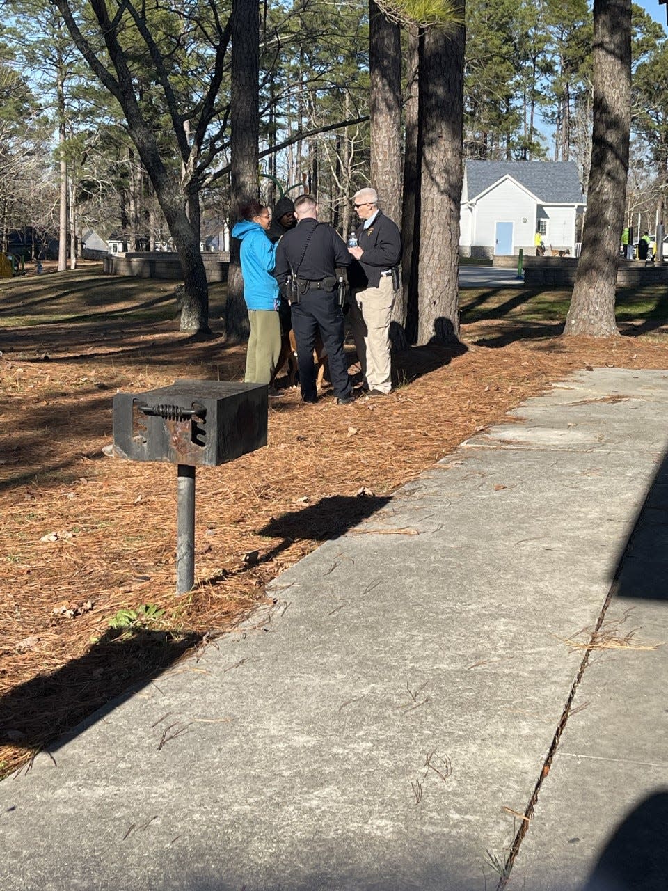 Amari's mother stands talking with officers.