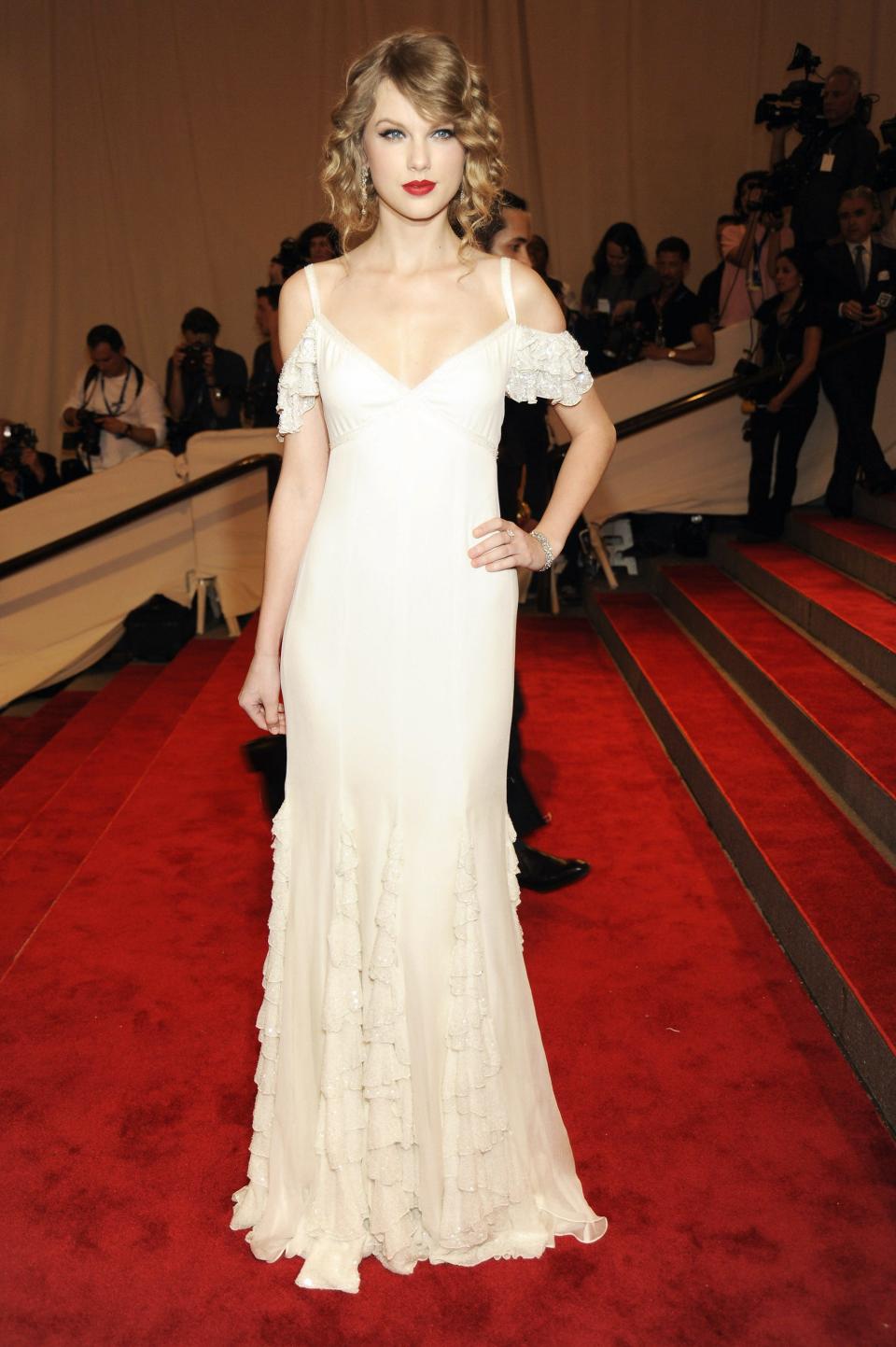 Taylor Swift wears a white dress on the Met Gala red carpet.