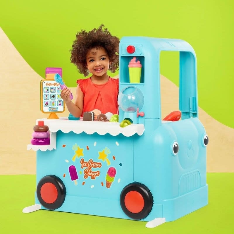 Child plays with ice cream shop toy