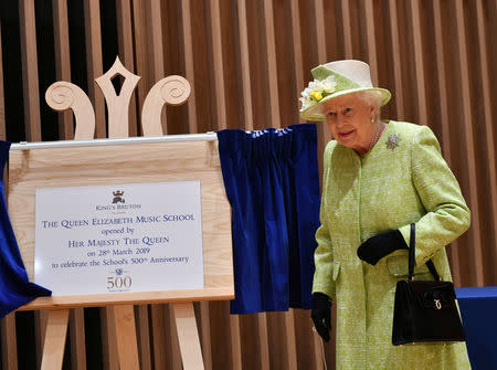Queen Elizabeth II unveils a plaque celebrating the school's 500th anniversary and opening their new music centre during a visit to King's Bruton School in Bruton, Somerset, Britain March 28, 2019. Ben Birchall/Pool via REUTERS