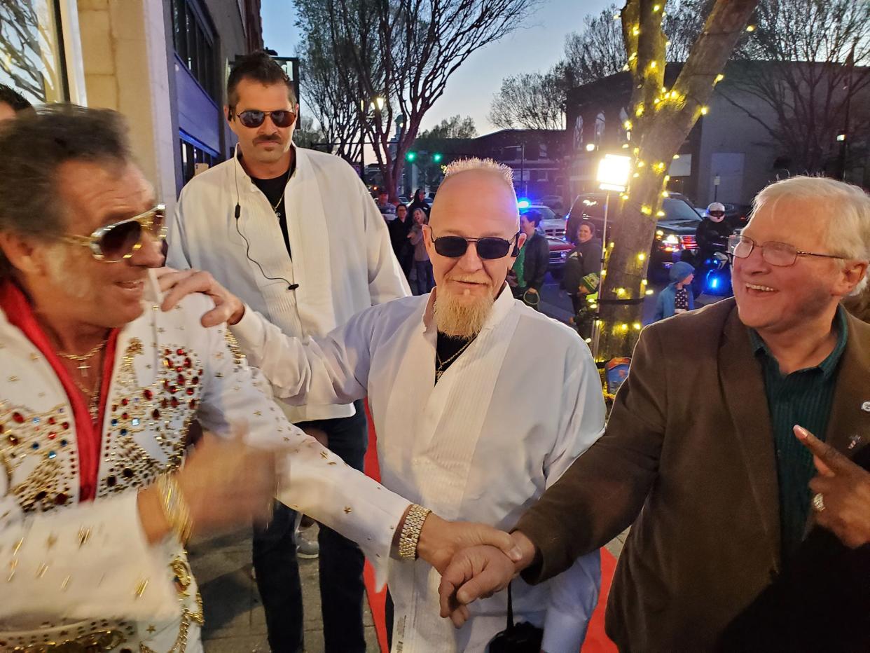 With bodyguards surrounding him. Elvis, played by Tim LeBeau,  shakes hands with Davidson County Commissioner Steve Shell Tuesday night as he walks into Red Donut Shop. The short video will be used to promote the Tribute Festival to the King happening in Lexington April 29-May1.