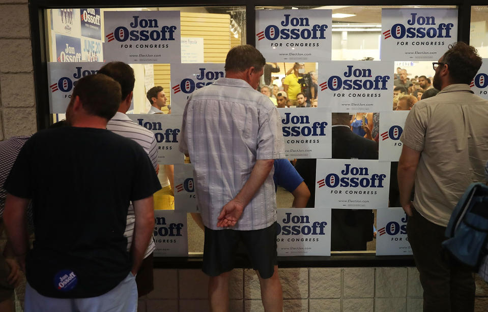 <p>People look through a window to watch as Democratic candidate Jon Ossoff speaks to volunteers and supporters on the last night before election day as he runs for Georgia’s 6th Congressional District on June 19, 2017 in Roswell, Ga. (Photo: Joe Raedle/Getty Images) </p>