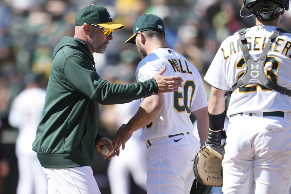 Oakland Athletics manager Mark Kotsay, left, makes a pitching change as he relieves pitcher Sam Moll (60) during the 10th inning of a baseball game against the New York Mets in Oakland, Calif., Sunday, April 16, 2023. (AP Photo/Jeff Chiu)