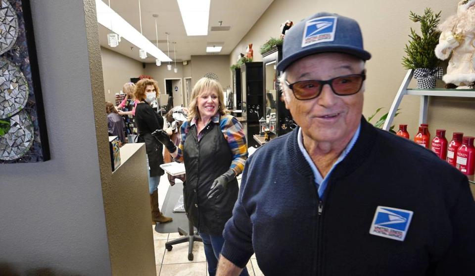 At Studio Salon, Kim Kunkel, middle, wishes letter carrier Dave Costa well in his retirement as he delivers the mail at McHenry Village in Modesto, Calif., Wednesday, Dec. 27, 2023. Costa is retiring Wednesday after more than 56 years with the Postal Service.