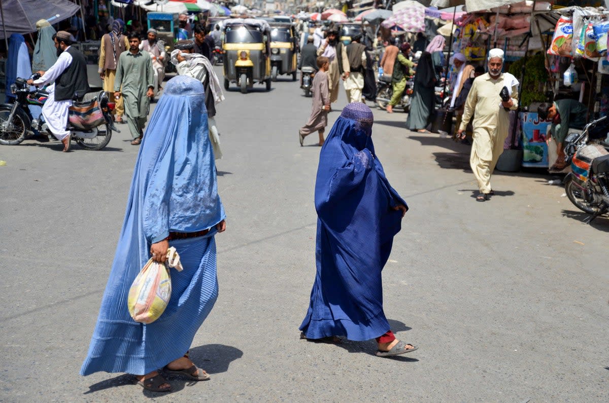 Afghan women walk along a road at a market area in Kandahar (AFP via Getty Images)