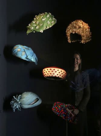 Gallery worker Caroline de Guitaut, curator at the royal collections trust, poses with part of the largest exhibition of The Queen's dresses and accessories ever shown in Scotland at the Palace of Holyroodhouse, Scotland April 20, 2016. REUTERS/Russell Cheyne