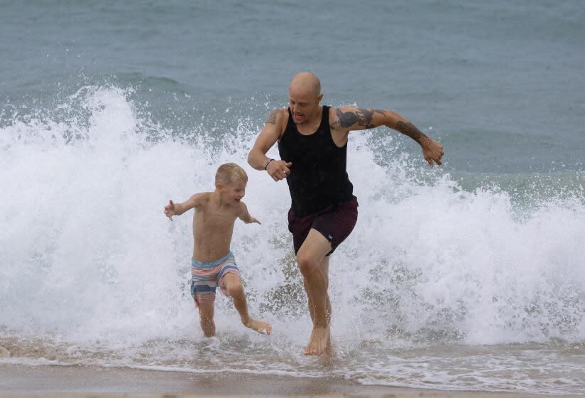 Jonah Herring, right, 39, and his friend's son Dominic Frizzell, 7, both from Brier, Washington, play at Manhattan Beach, California, August 20, 203. (Photo by Ringo Chiu / For The Times)