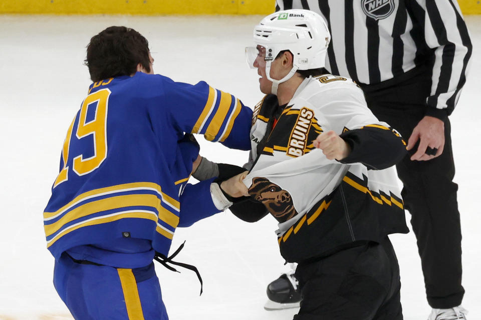Buffalo Sabres center Peyton Krebs (19) and Boston Bruins defenseman Connor Clifton (75) fight during the second period of an NHL hockey game, Saturday, Dec. 31, 2022, in Boston. (AP Photo/Mary Schwalm)