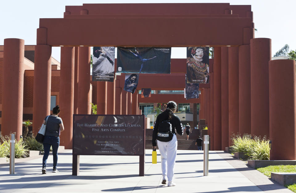 Students walk past the Harriet and Charles Luckman Fine Arts Complex at the The Cal State University, Los Angeles campus Thursday, April 25, 2019. Hundreds of students and staff at two Los Angeles universities, including Cal State University, have been placed under quarantine because they may have been exposed to measles and either have not been vaccinated or cannot verify that they are immune, officials said Thursday. (AP Photo/Damian Dovarganes)