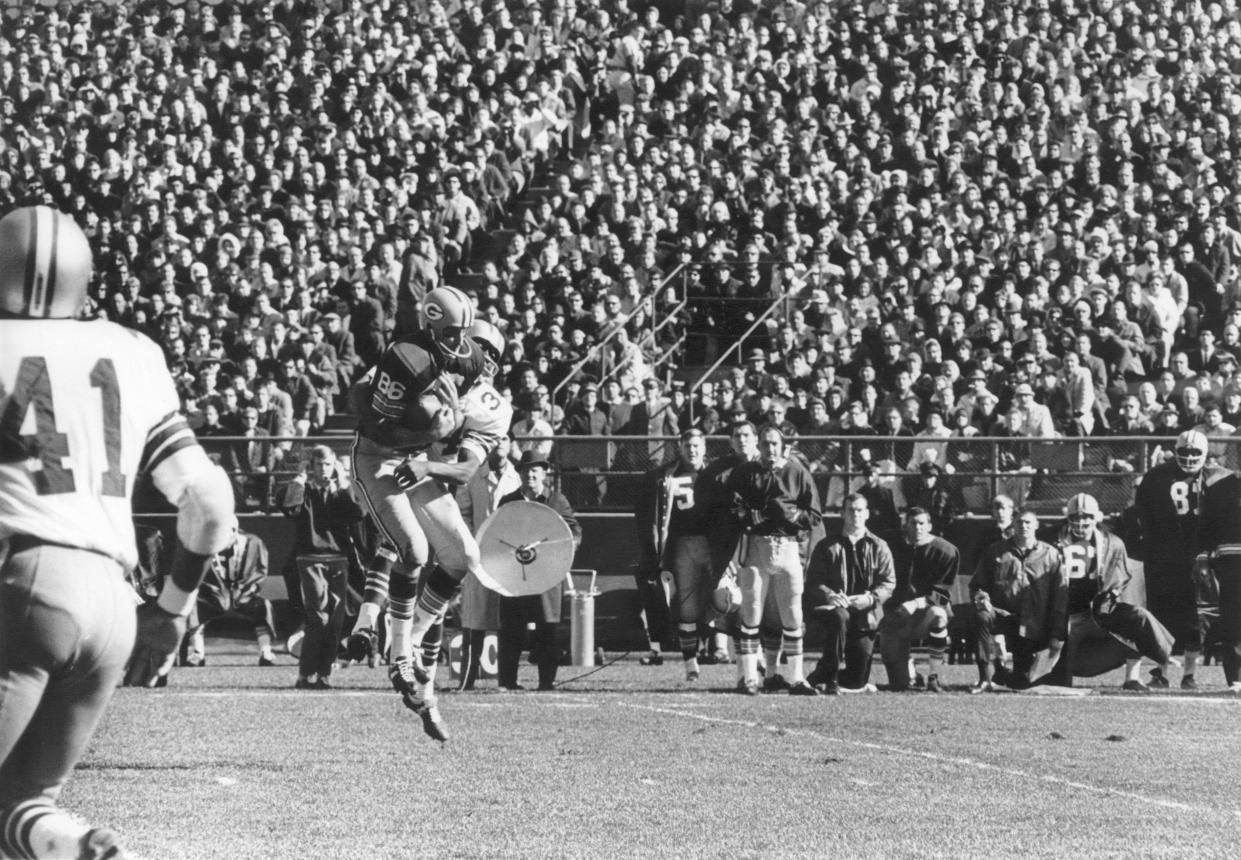 Green Bay receiver Boyd Dowler leaps high to grab a Bart Starr pass.