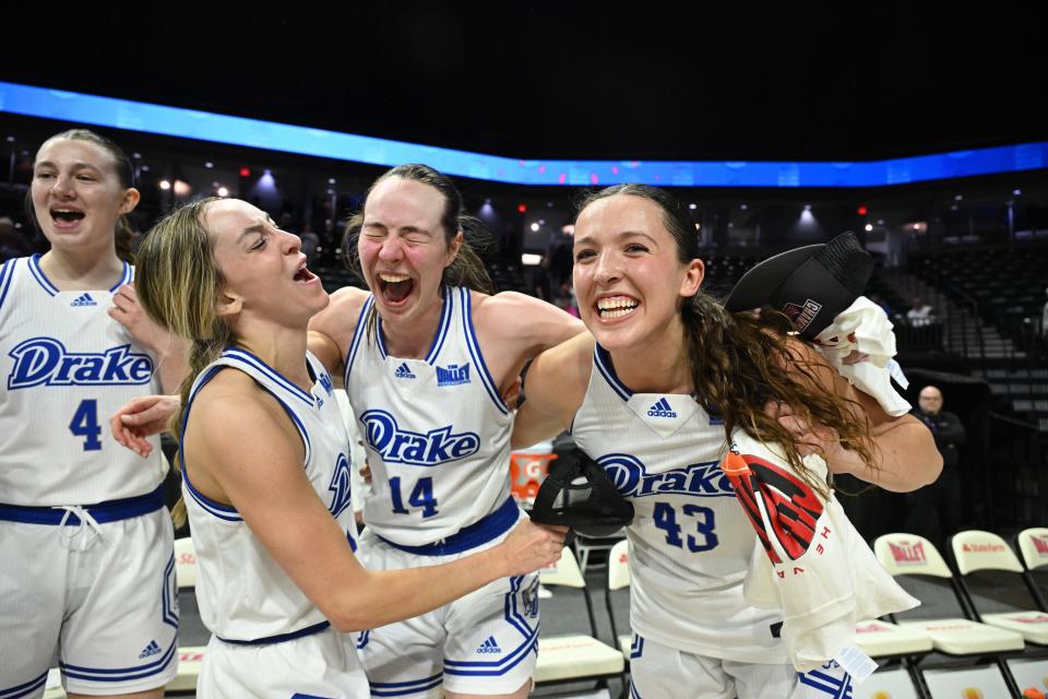 Drake's Anna Miller (14) celebrates with teammates Taylor McAuley, left, and Grace Berg after Miller's game-winning shot at the buzzer gave the Bulldogs the Missouri Valley Tournament championship.