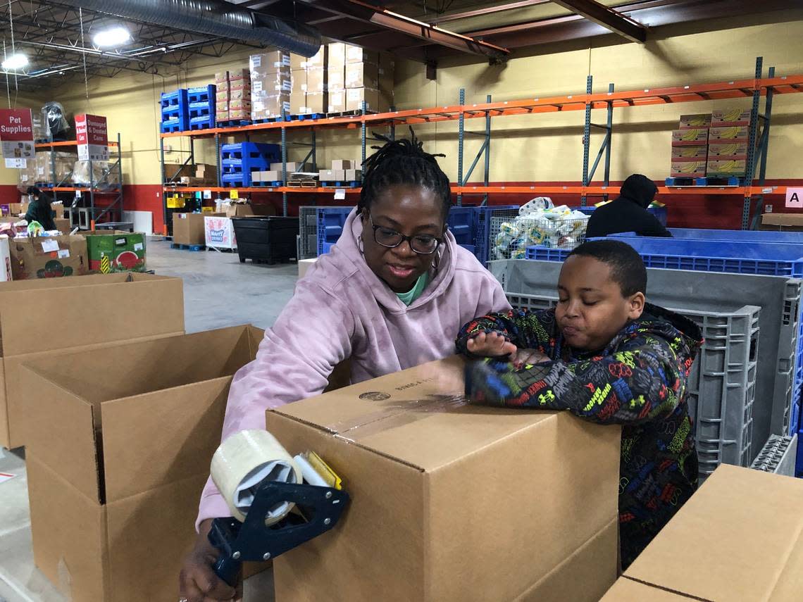 Monica Roland, left, volunteers with her son, Braylan, at a Harvesters food bank event on Martin Luther King Jr. Day in Kansas City.