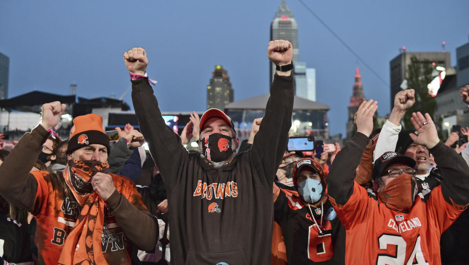 Cleveland Browns fans celebrate the second round pick, Jeremiah Owusu-Koramoah, linebacker for Notre Dame, at the NFL football draft, Friday, April 30, 2021, in Cleveland. (AP Photo/David Dermer)