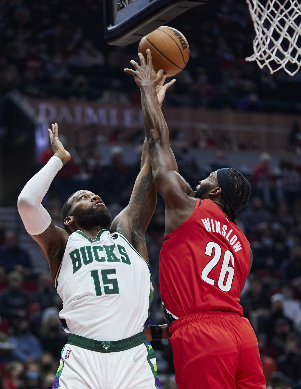 Milwaukee Bucks guard Jeff Dowtin, left, has a shot blocked by Portland Trail Blazers forward Justise Winslow during the first half of an NBA basketball game in Portland, Ore., Saturday, Feb. 5, 2022. (AP Photo/Craig Mitchelldyer)