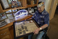 CORRECTS AGE TO 101 INSTEAD OF 102 - Pearl Harbor survivor Lou Conter, 101, holds a framed replica of the Honolulu Star-Bulletin of Dec. 7, 1941 at his home in Grass Valley, Calif., Friday, Nov. 18, 2022. Conter survived the devastating explosion that destroyed the battleship, USS Arizona, during the Japanese attack on Pearl Harbor, Dec. 7, 1941.(AP Photo/Rich Pedroncelli)