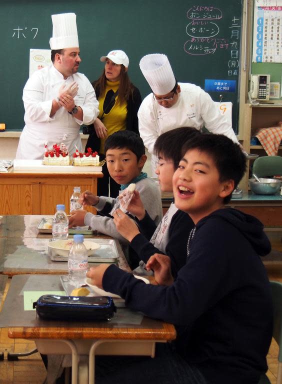 Pupils eat French cuisine and cakes cooked by French chef Christoph Paucod (back L) for their lunch at an elementary school in Koriyama, on December 9, 2013