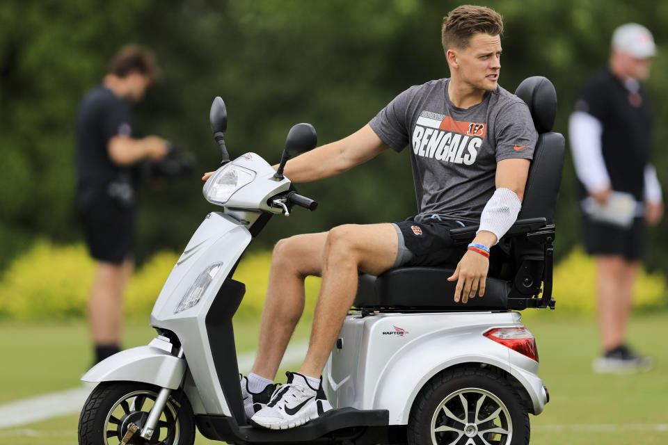 Cincinnati Bengals' Joe Burrow sits on a scooter as he watches during the NFL football team's training camp in Cincinnati, Monday, Aug. 1, 2022. (AP Photo/Aaron Doster)