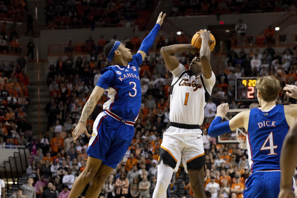 Oklahoma State's Bryce Thompson (1) shoots over Kansas's Dajuan Harris Jr. (3) in the first half of an NCAA college basketball game in Stillwater, Okla., Tuesday, Feb. 14, 2023. (AP Photo/Mitch Alcala)