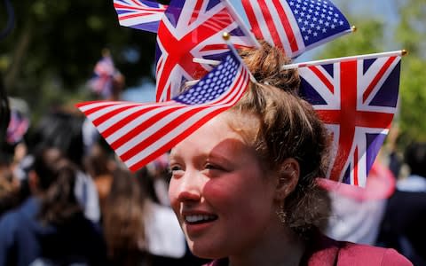 A student at Meghan Markle's former Los Angeles high school wears British and American flags she takes part in a 'Here's to Meghan!' celebration - Credit:  REUTERS/Mike Blake 