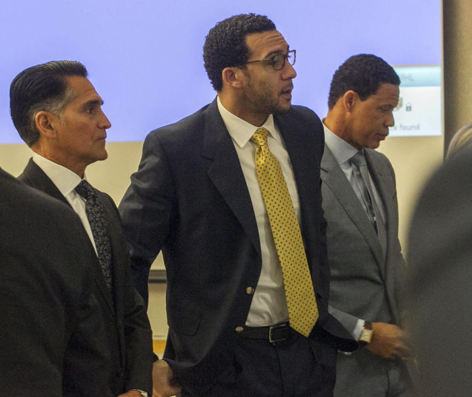 Former NFL football player Kellen Winslow Jr., center, stands as the jury enters the courtroom on the first day of his rape trial, Monday May 20, 2019, in Vista, Calif. Winslow's attorneys Brian Watkins, right, and Marc Carlo, left, flank him. (John Gibbins/The San Diego Union-Tribune via AP, Pool)