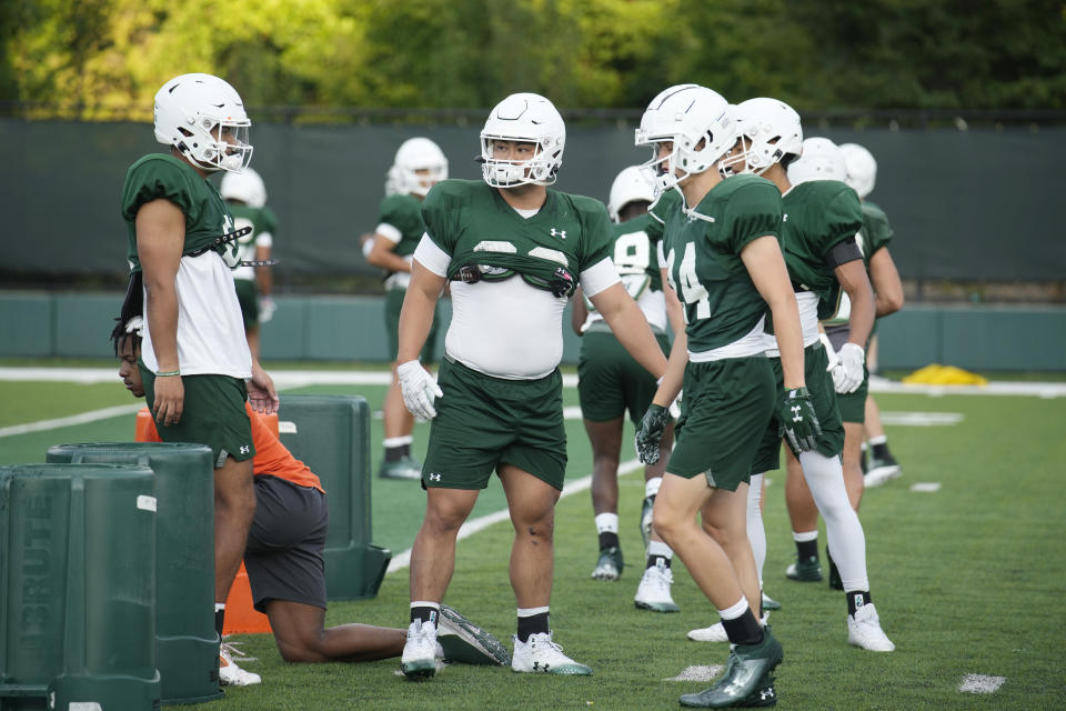 Colorado State defensive lineman Hidetora Hanada, center, takes part in drills during the team's NCAA college football practice on the university's campus Tuesday, Aug. 8, 2023, in Fort Collins, Colo. Hanada was a highly ranked sumo wrestler in Japan. He decided he wanted to try something different so he arrived at Colorado State where he is learning to be a defensive lineman for the Rams. (AP Photo/David Zalubowski)