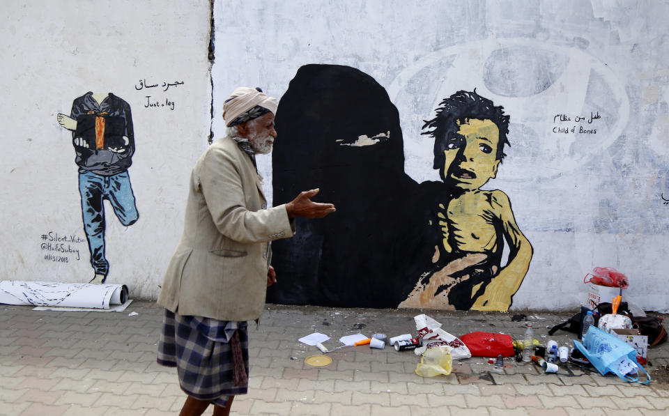 A man begs as he passes graffiti painted during an anti-war campaign on February 21, 2019 in Sana’a, Yemen. Image: Getty