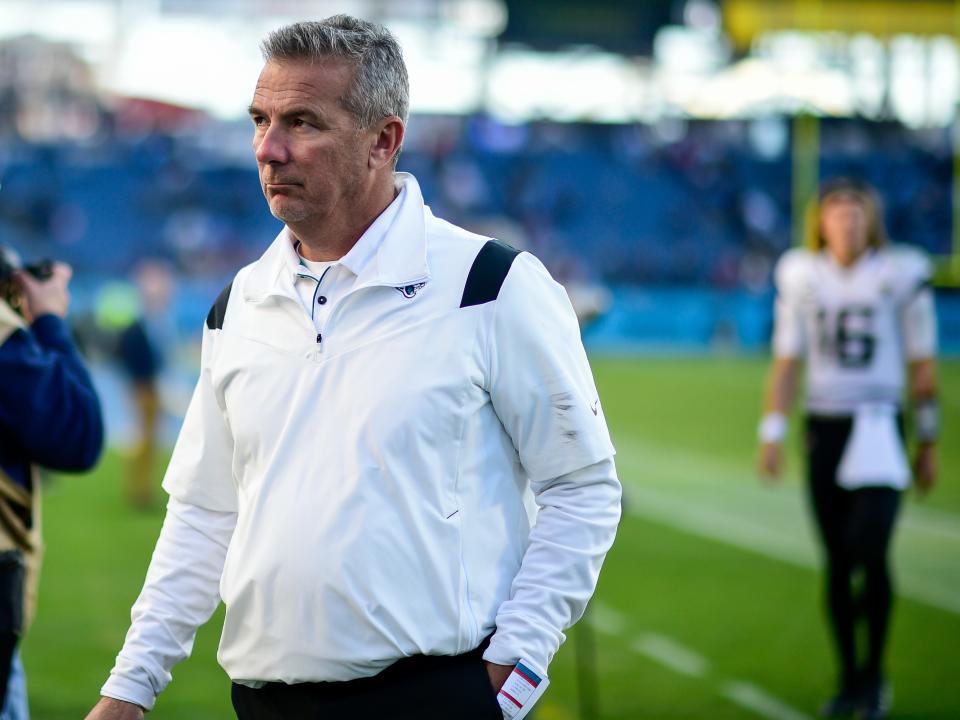 Urban Meyer is followed by quarterback Trevor Lawrence as he walks off the field in his final game as Jacksonville Jaguars head coach.