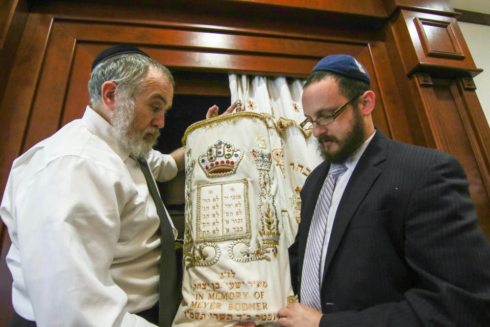 Rabbi Chuni Vogel (left) and Rabbi Motti Flikshtein prepare to return a covered Torah to the Aron Kodesh during preparations for Rosh Hashanah at the Chabad Center for Jewish Life, near Wilmington, on Sunday, Oct. 2, 2016.