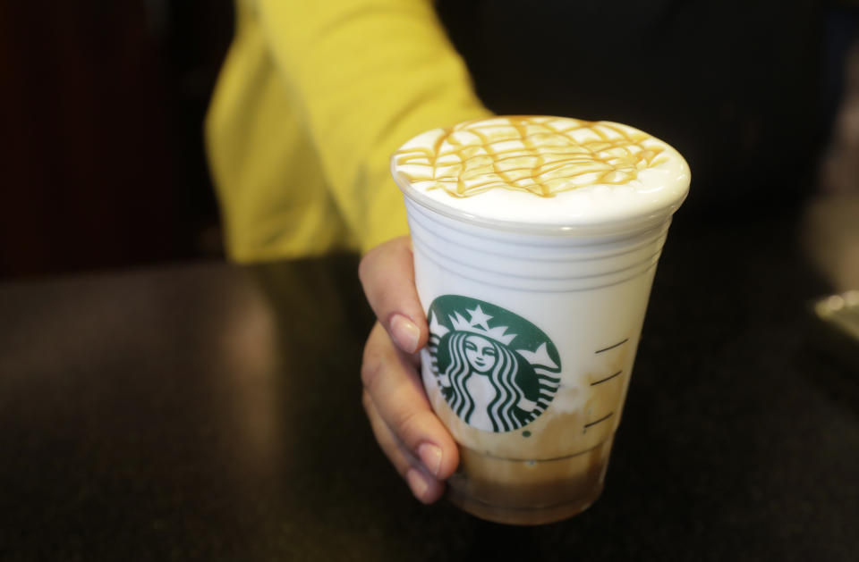 FILE- In this March 5, 2019, file photo Esmeralda Chapparro, a Starbucks barista, moves a finished Cloud Macchiato coffee drink to the counter as she works at a store in the company's headquarters building in Seattle's SODO neighborhood. Starbucks Corp. reports earns on Thursday, April 25. (AP Photo/Ted S. Warren, File)