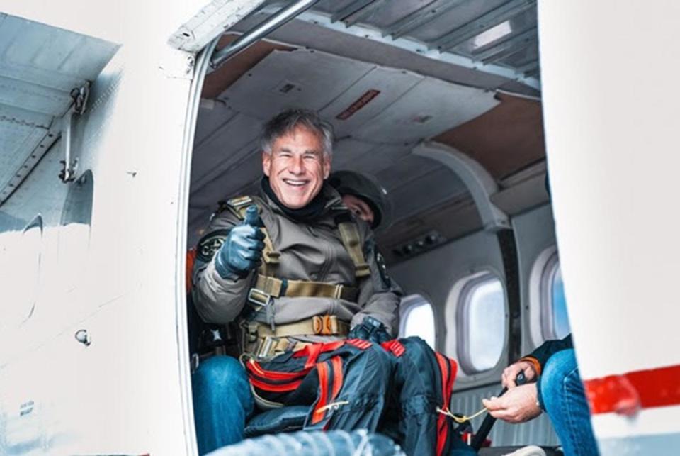 Gov. Greg Abbott gives the thumbs up for an airplane before skydiving with 106-year-old World War II veteran Al Blaschke in San Marcos on Nov. 27, 2023. The governor skydived for his first time with Blaschke, who holds the the Guinness World Record for the world's oldest tandem parachute jump.