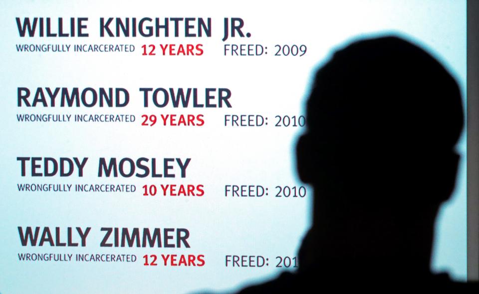 A University of Akron student looks on as a list of innocent men freed by the Ohio Innocence Project is displayed on the screen Wednesday during a program at the University of Akron.