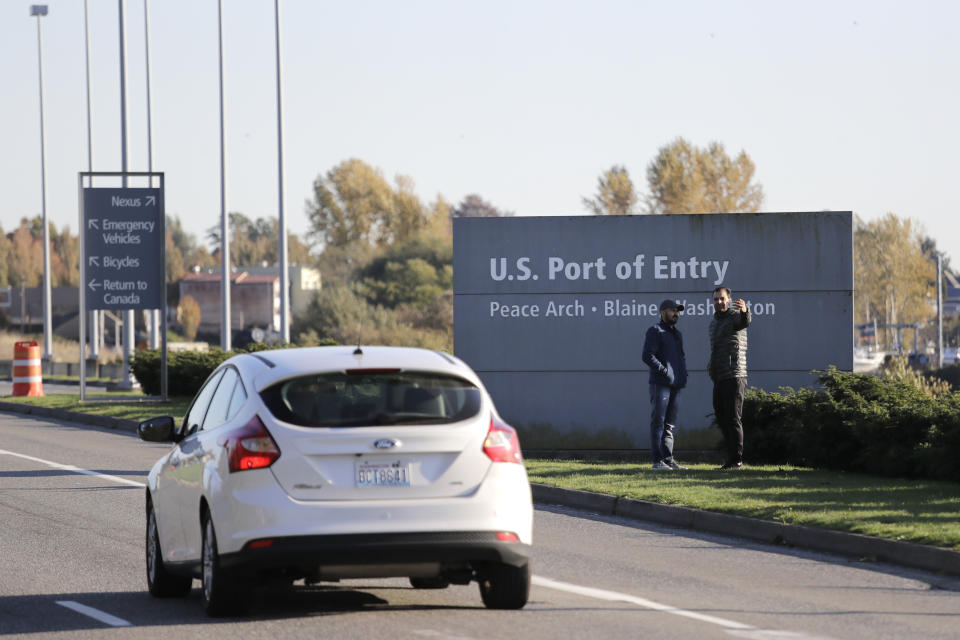 FILE - In this Oct. 9, 2019, file photo, pedestrians take a photo at an entry sign as traffic enters the United States from Canada at the Peace Arch Border Crossing in Blaine, Wash. U.S. Rep. Pramila Jayapal said Thursday, Jan. 30, 2020, she is working to authenticate an apparently leaked document showing that Customs and Border Protection agents on the U.S.-Canada border in Washington state were in fact ordered to detain Iranian and Iranian-American travelers early this month, despite initial agency denials. (AP Photo/Elaine Thompson, File)