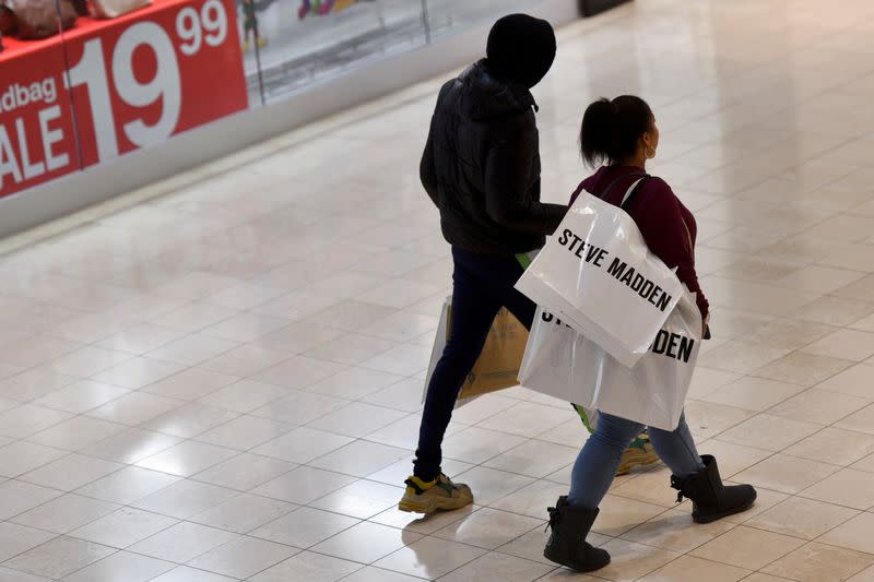 Shoppers walk with Steve Madden bags as holiday shopping accelerates at the King of Prussia Mall