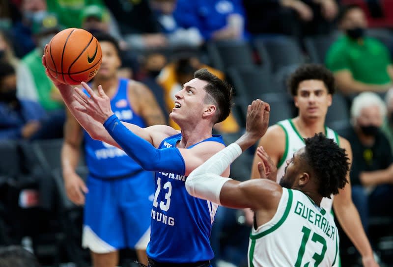 BYU guard Alex Barcello, left, shoots next to Oregon forward Quincy Guerrier during the second half of an NCAA college basketball game in Portland, Ore., Tuesday, Nov. 16, 2021. | Craig Mitchelldyer, Associated Press