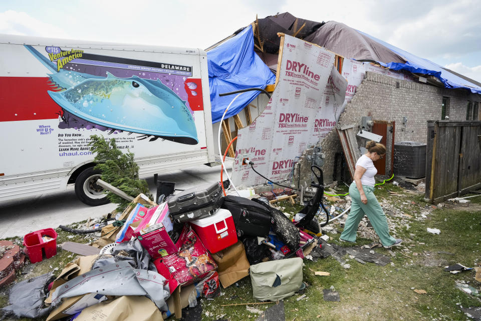 A woman named Olga, who declined to give her last name, walks around her heavily damaged home as her family begins cleaning up storm damage, Sunday, May 19, 2024, in Cypress, Texas. (Brett Coomer/Houston Chronicle via AP)