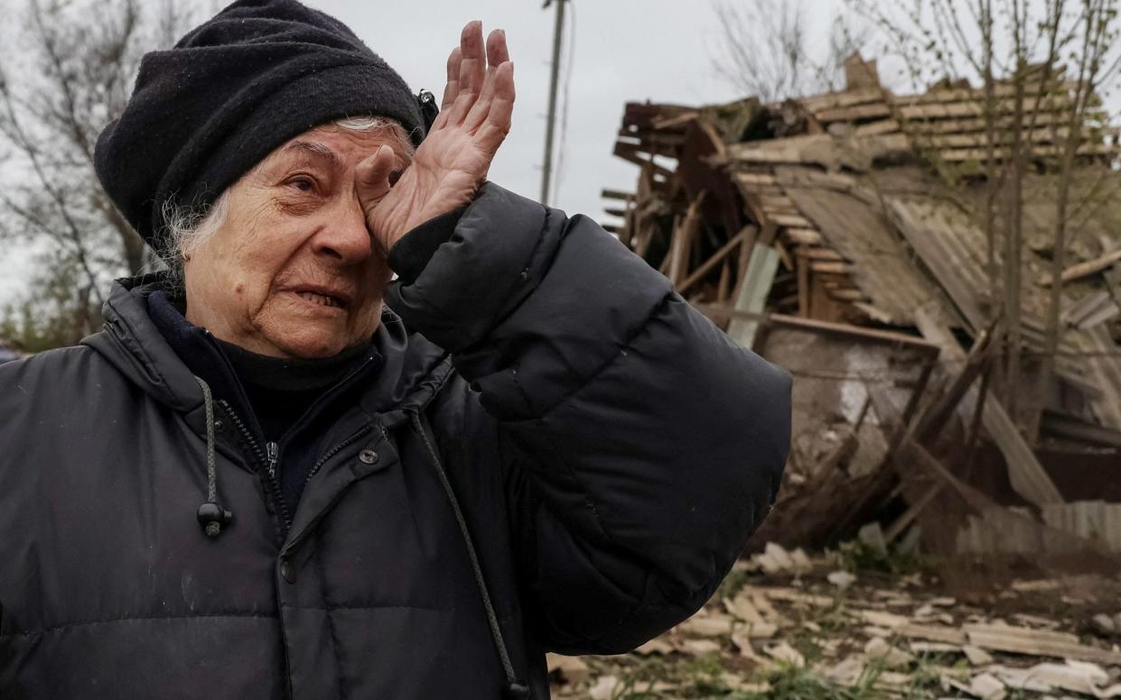 A local resident Liubov Vasylieva, 77, reacts as she stands among remains in a yard of her house hit by a Russian military strike, amid Russia's attack on Ukraine, in the town of Pavlohrad - Sofiia Gatilova/Reuters