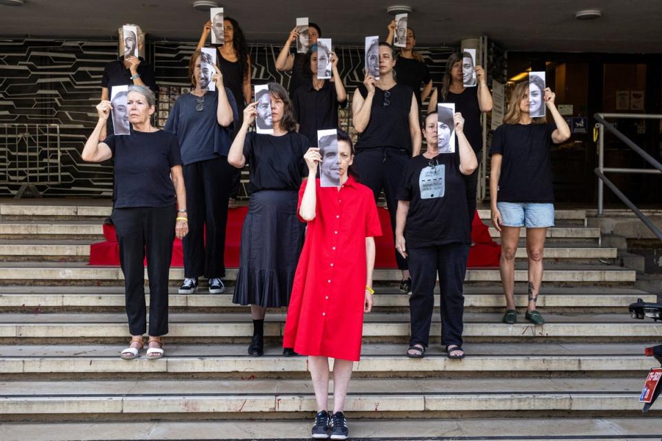 Relatives and supporters hold pictures of hostages kidnapped into Gaza during a Tel Aviv protest calling for their return (REUTERS)