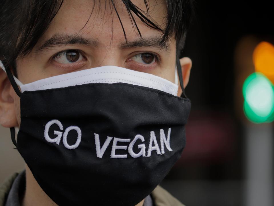 An activist wears a face mask with the slogan Go Vegan in the Zócalo of Mexico City as part of the launch of the Plant Based Treaty campaign.