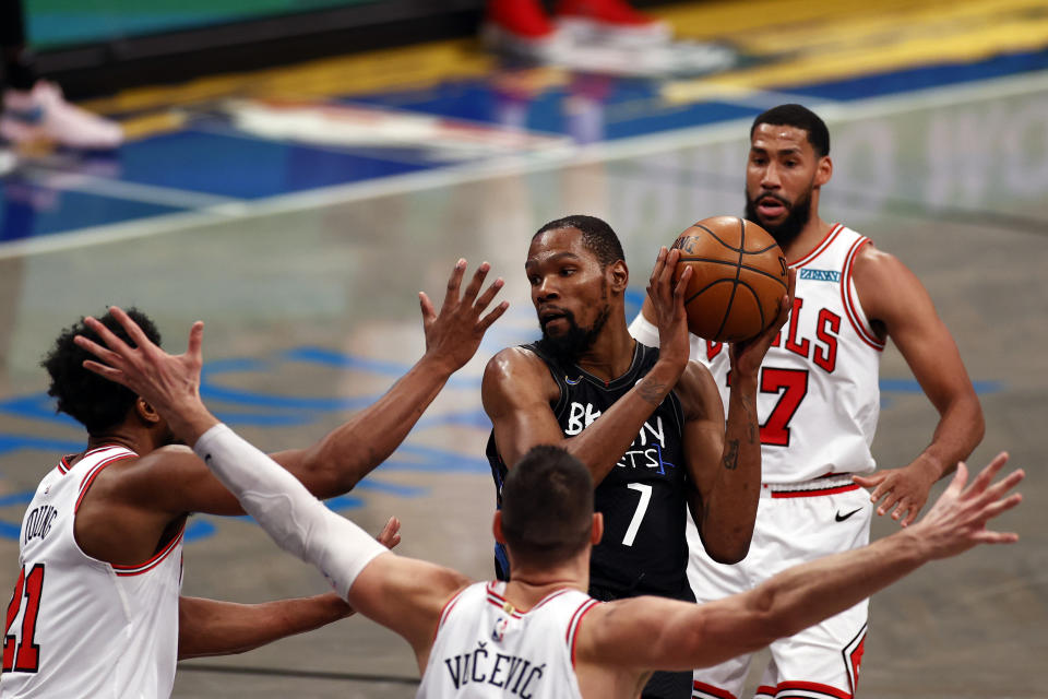 Brooklyn Nets forward Kevin Durant (7) looks to pass around Chicago Bulls forward Thaddeus Young, left, during the second half of an NBA basketball game Saturday, May 15, 2021, in New York. (AP Photo/Adam Hunger)