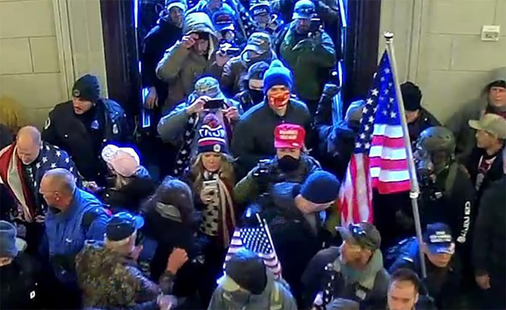 Jenna Ryan, center, looking at her phone while entering the Capitol on Jan. 6. (U.S. Attorney's Office)