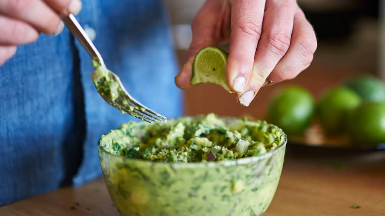 Close-up of hands making guacamole