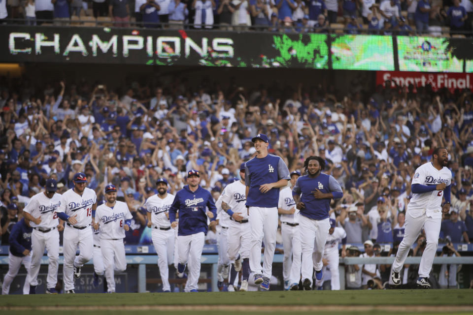 Los Angeles Dodgers players run onto the field to celebrate the team's 5-2 win against the Colorado Rockies in a tiebreaker baseball game, Monday, Oct. 1, 2018, in Los Angeles. (AP Photo/Jae C. Hong)