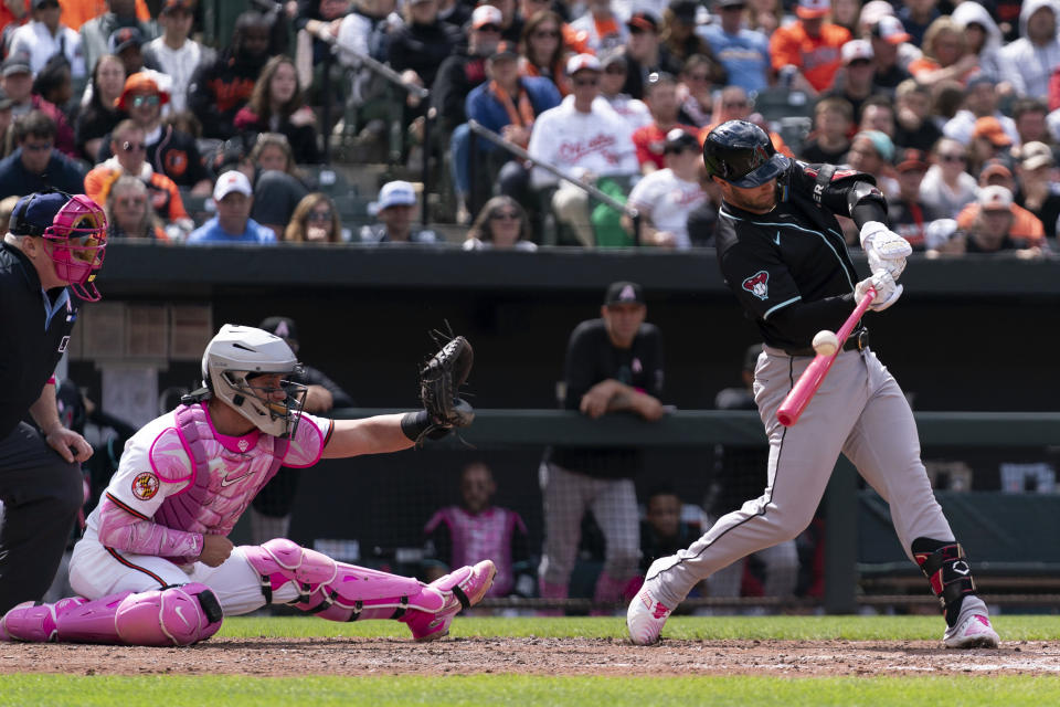 Arizona Diamondbacks' Christian Walker, right, hits during a baseball game against the Baltimore Orioles, Sunday, May 12, 2024, in Baltimore. (AP Photo/Jose Luis Magana)