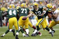 Green Bay Packers quarterback Aaron Rodgers (C) hands off the ball to running back James Starks (L) during the first half of their NFL football game against the Washington Redskins in Green Bay, Wisconsin September 15, 2013. The Packers defeated the Redskins 38-20. REUTERS/Darren Hauck