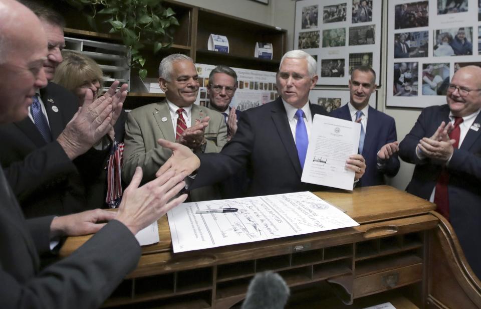 Republican Vice President Mike Pence, center, speaks to Secretary of State Bill Gardner, left, as Pence files for President Donald Trump to be listed on the New Hampshire primary ballot, Thursday, Nov. 7, 2019, in Concord, N.H. (AP Photo/Charles Krupa)