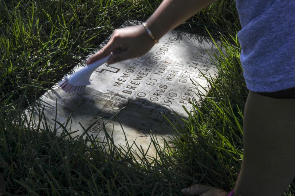 Sangmin Lim, a UCLA graduate student, cleansa headstone