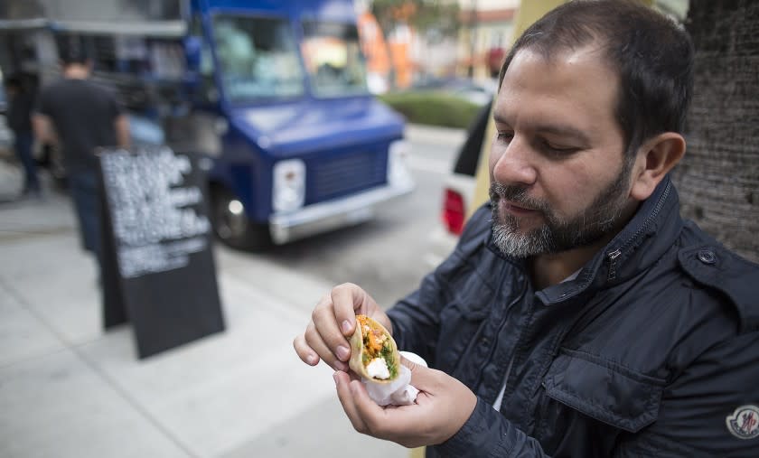 CULVER CITY, CALIF. -- WEDNESDAY, MARCH 30, 2016: Chef Enrique Olvera eats a sweet potato taco at Guerrilla Tacos in Culver City, Calif., on March 30, 2016. (Brian van der Brug / Los Angeles Times)