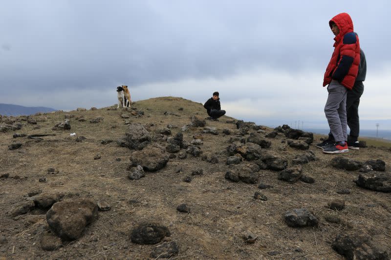 Residents look at a crater caused by a missile launched by Iran on U.S.-led coalition forces on the outskirts of Duhok