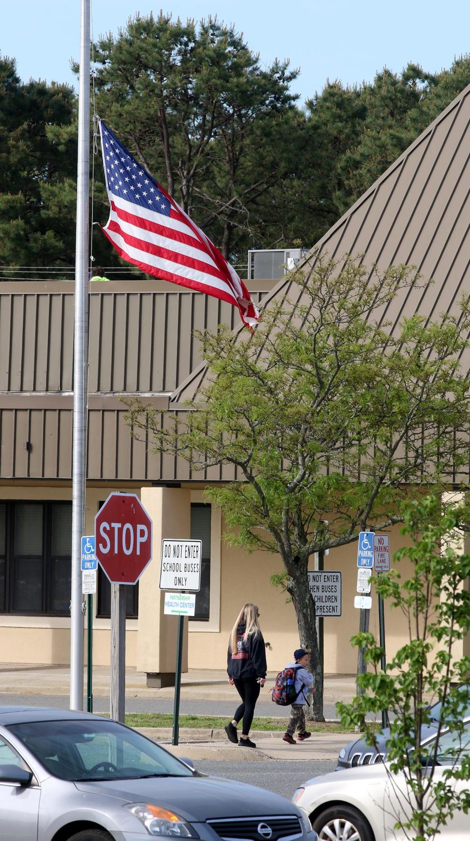 The US Flag flies at half staff outside a school in Brick field Wednesday morning, May 25, 2022.   The flag was lowered in memory of those killed in the Texas school shooting.