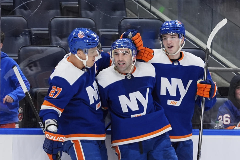 New York Islanders' Kyle Palmieri, center, celebrates with Anders Lee, left, and Noah Dobson after scoring a goal against the St. Louis Blues during the second period of an NHL hockey game Tuesday, March 5, 2024, in Elmont, N.Y. (AP Photo/Frank Franklin II)